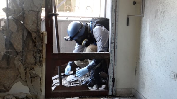 A UN worker inspects the site of an alleged chemical weapons attack in Syria