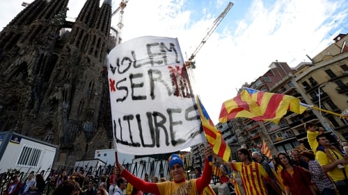 A Catalan holds a banner reading 'We want to be free' as he and thousands of Catalans gather to create a 400km human chain in front of the Sagrada Familia basilica in Barcelona