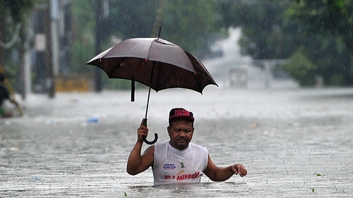 A man walks through deep floodwater in Manila, Philippines, where the typhoon has brought heavy rains
