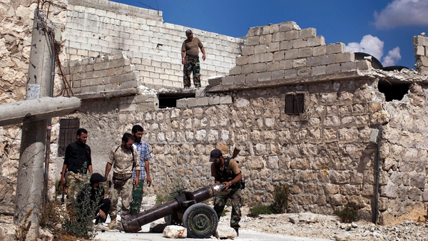 Rebel fighters load a shell into a cannon aimed at pro-regime forces in the Sheik Said neighbourhood of Syria's northern city of Aleppo