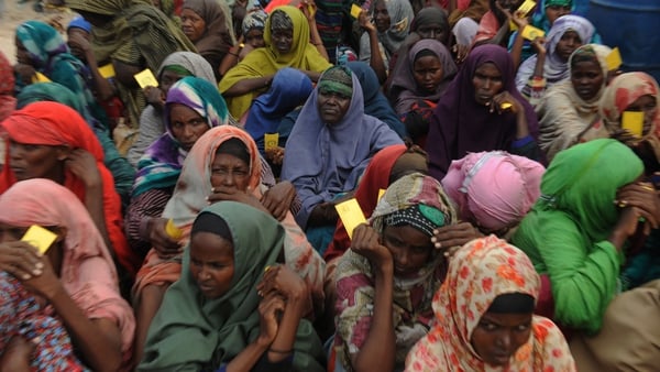 Somali women queue to receive food at a refugee camp in Mogadishu