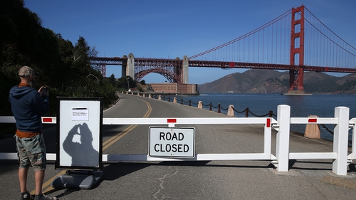 A visitor takes a picture of a sign announcing the closure of the Fort Point National Historic Site in San Francisco