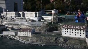 A woman takes a photograph of a scale model of Alcatraz, after the official tour was closed