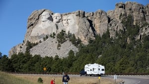 Tourists view Mount Rushmore from the road after the national park was shut