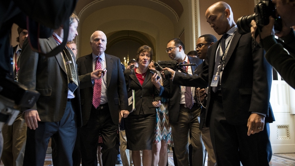 US Senators John McCain and Susan Collins talk to reporters while heading to the Senate floor