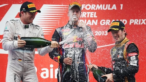 Sebastian Vettel is champagne-soaked by Nico Rosberg (L) third placed Romain Grosjean (R)