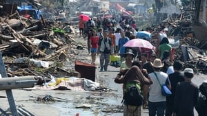 Locals walk through debris and victim's bodies in Tacloban City, Leyte province