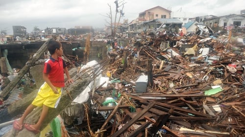 A young boy views the destruction in Tacloban, which bore the brunt of the typhoon
