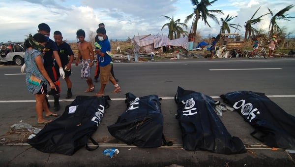 Bodies are lined up in body bags on the roadside as members of the fire department retrieve bodies from the rubble in Tacloban City