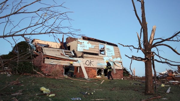 Firefighters search a heavily damaged home in Washington, Illinois