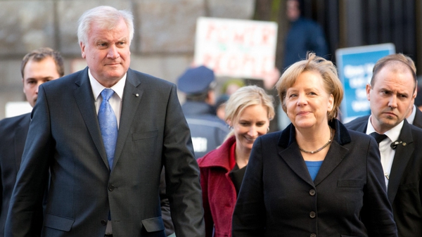 CSU chairman Horst Seehofer (L), and Angela Merkel arrive at SPD headquarters for coalition talks
