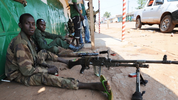 Ex-Seleka rebel ebels sits in the shade as they stand guard at a shut down market in Bangui