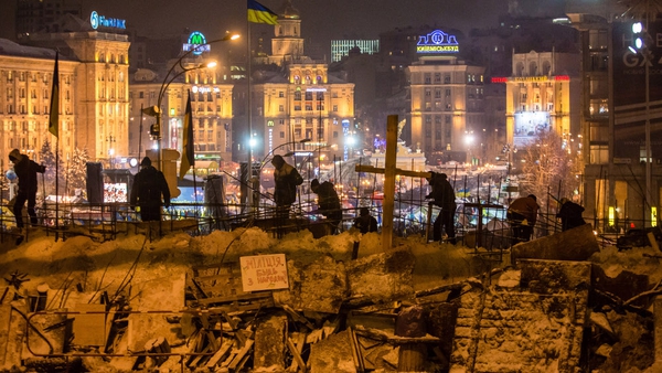 Protesters use snow to reinforce a barricade blocking street access to Independence Square