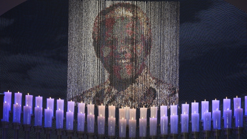 Candles are lit under a portrait of Neslon Mandela before the funeral ceremony of South African former president Nelson Mandela in Qunu