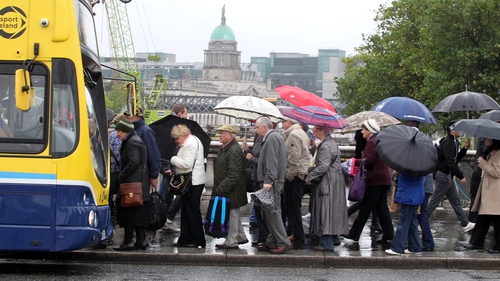 People queue for a bus in the rain in Dublin (Pic: Sam Boal/Photocall)
