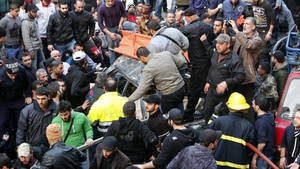 Residents and emergency personnel gather at the site of the blast