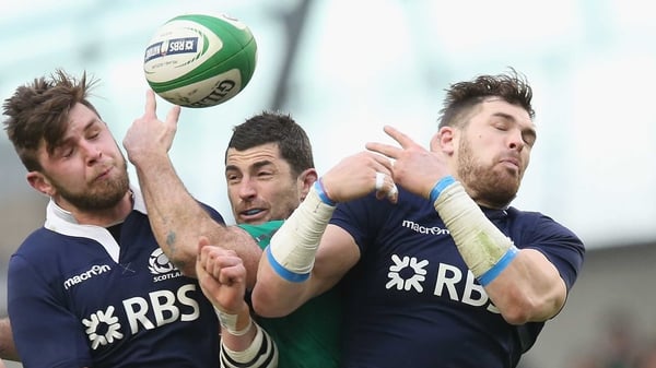 Rob Kearney of Ireland attempts to catch the ball as Ryan Wilson (L) and Sean Lamont challenge