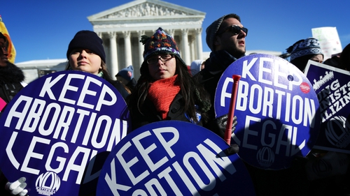Pro-choice activists hold signs as marchers of the annual March for Life arrive in front of the US