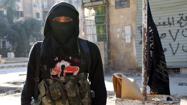 A member of jihadist group al-Nusra Front stands in a street of the northern Syrian city of Aleppo