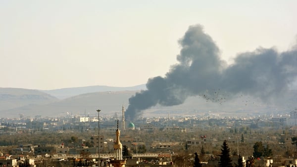 Smoke billows from buildings following a reported air strike by government forces on the Qadam suburb on the outskirts of the Syrian capital Damascus