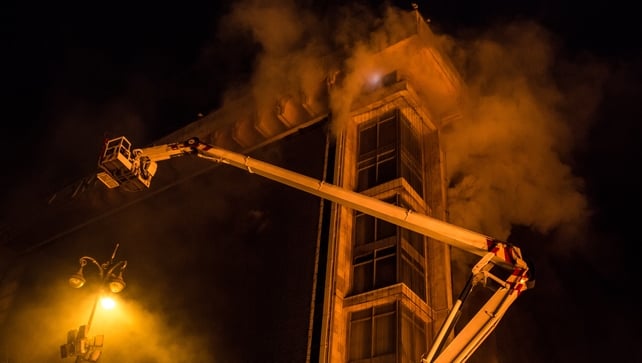 A fire truck is used to rescue people from the upper floors of the burning Trade Unions Building