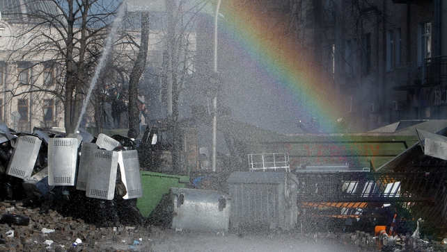 Protesters clash with riot police as a rainbow appears during continuing protests in downtown Kiev (EPA)