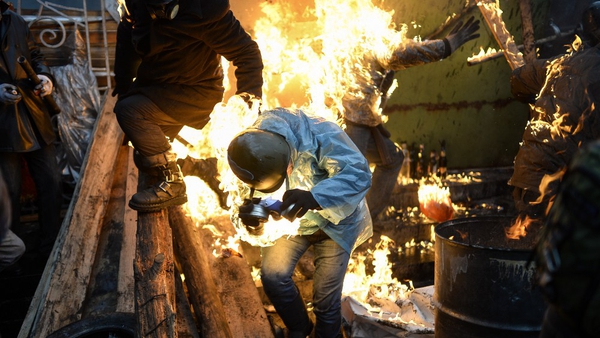 Protesters burn as the stand behind barricades during clashes with police