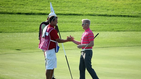 Simon Dyson shakes hands with his caddie on the 18th green