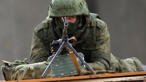 Heavily-armed soldiers without identifying insignia and pro-Russian militants guard the Crimean parliament building