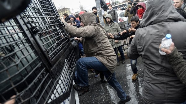 Turkish protesters attack a riot police vehicle during clashes outside the Okmeydani Hospital