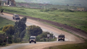 Israeli army vehicles patrol at the border between Israel and Gaza