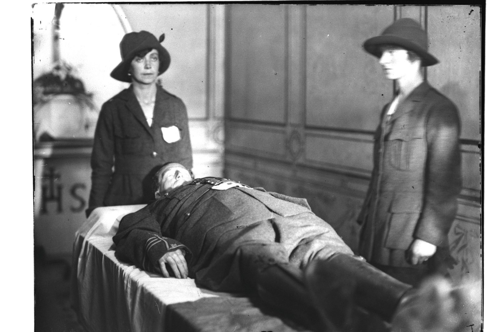 Image - Two uniformed Cumann na mBan members stand guard over the body of Cathal Brugha, killed in the Battle of Dublin in 1922. The women played an active part in the subsequent guerrilla phase of the war © RTÉ Photographic Archive