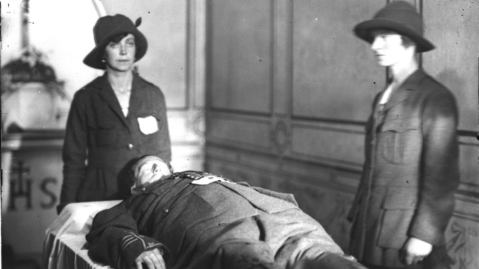 Image - Two uniformed Cumann na mBan members stand guard over the body of Cathal Brugha in 1922. © RTÉ Photographic Archives