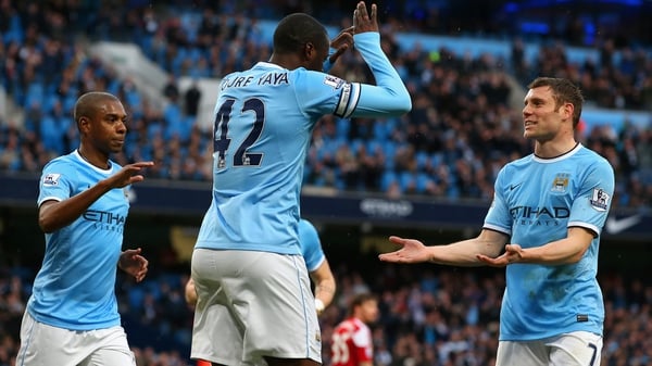 Yaya Toure (c) celebrates scoring City's opening goal from the penalty spot with James Milner