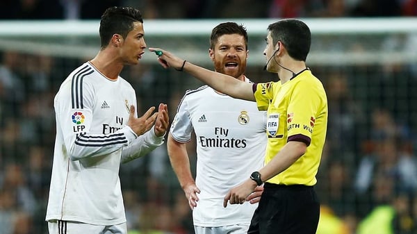 Cristiano Ronaldo (L) and Xabi Alonso of Real Madrid argue with referee Alberto Undiano Mallenco