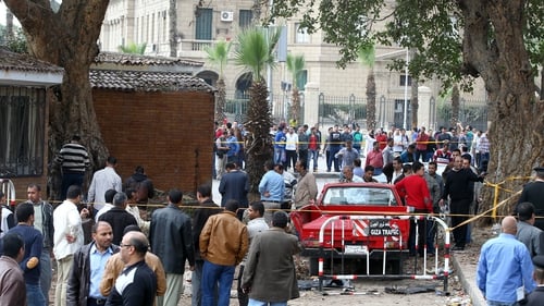 Egyptian security officers and people inspect the scene of the explosion near Cairo University (Pic: EPA)