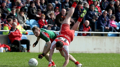 Derry's James Kearney takes a tumble while tussling with Colm Boyle of Mayo