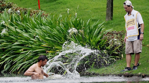 Pablo Larrazabal jumps into a water hazard in an attempt to avoid attacking hornets
