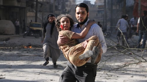 A man carries a wounded girl following an explosion in the northern Syrian city of Aleppo