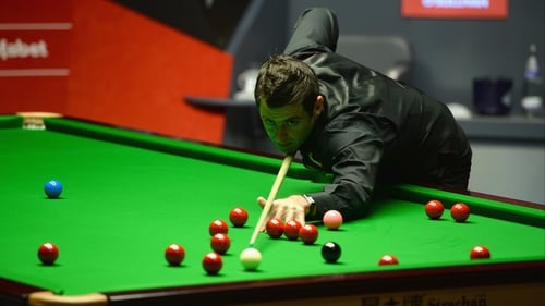 Ronnie O'Sullivan lines up a shot against Barry Hawkins