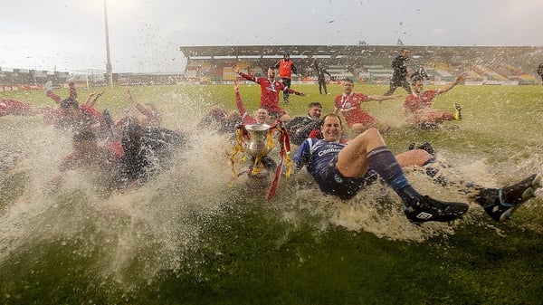 Sligo Rovers players celebrate on the rain-soaked pitch at the end of the final