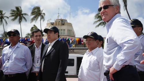 Douangchay Phichit is pictured standing beside US Defence Secretary Chuck Hagel