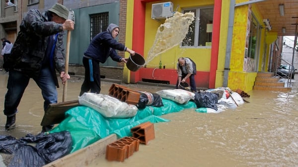 Residents try to set up a mini dam in front of their building in the town of Obrenovac, Serbia