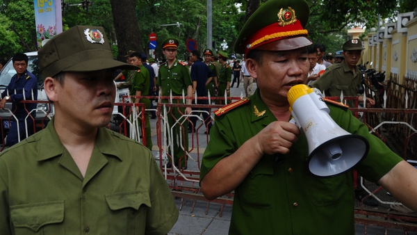 Policemen ask people to leave a street near to the Chinese embassy in Hanoi