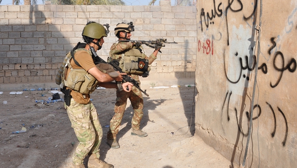 Members of the Iraqi security forces take positions in fighting against anti-government forces in Fallujah
