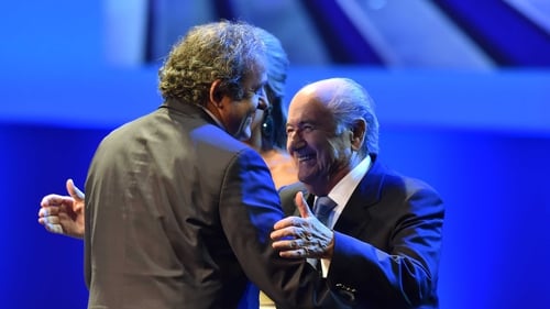 FIFA President Sepp Blatter (r) embraces UEFA President Michel Platini
