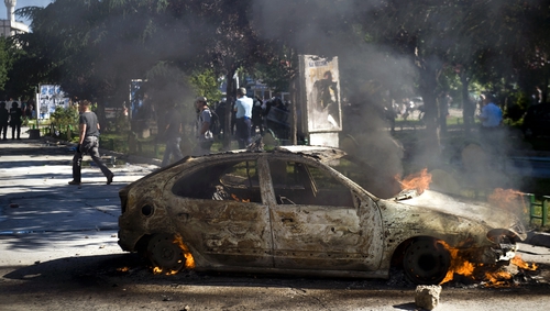 A vehicle burns during clashes between riot-police and protesters in the divided town of Mitrovica