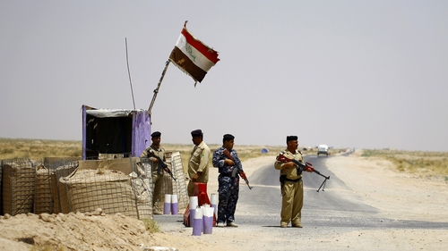 Shia fighters secure an area west of the central holy city of Najaf on a road leading to Anbar