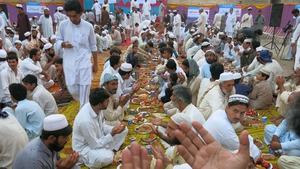 Internally displaced Pakistani civilians pray before breaking their fast during Ramadan