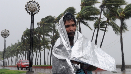 A man walks through heavy wind and rain as Typhoon Rammasun barrels across Manila
